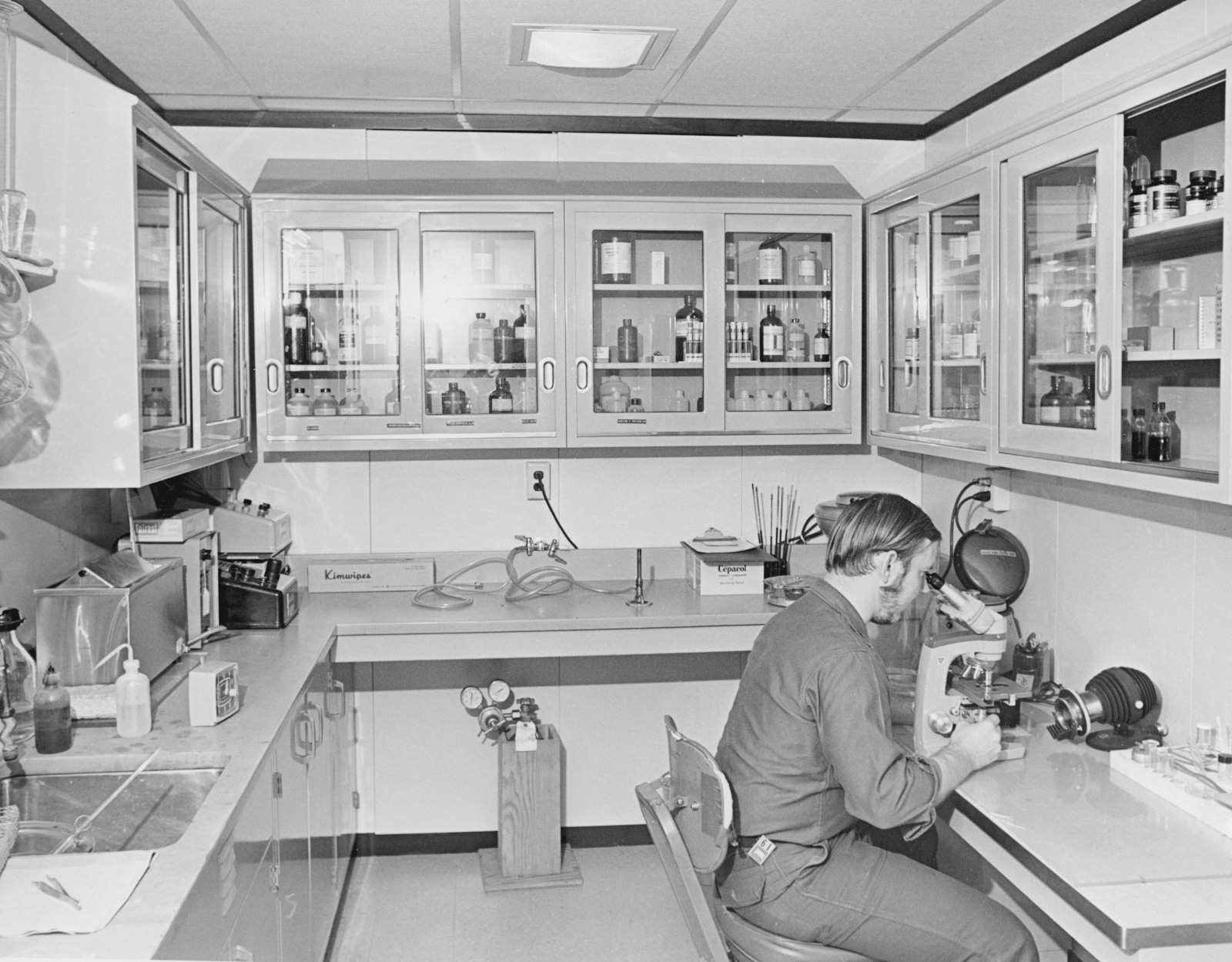 Researcher working at a lab bench with glassware